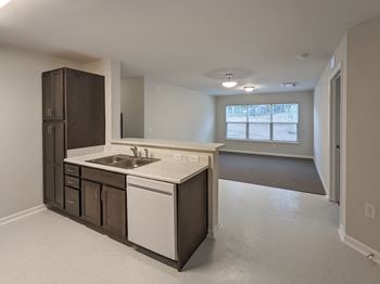 A kitchen with white countertops and brown cabinets.